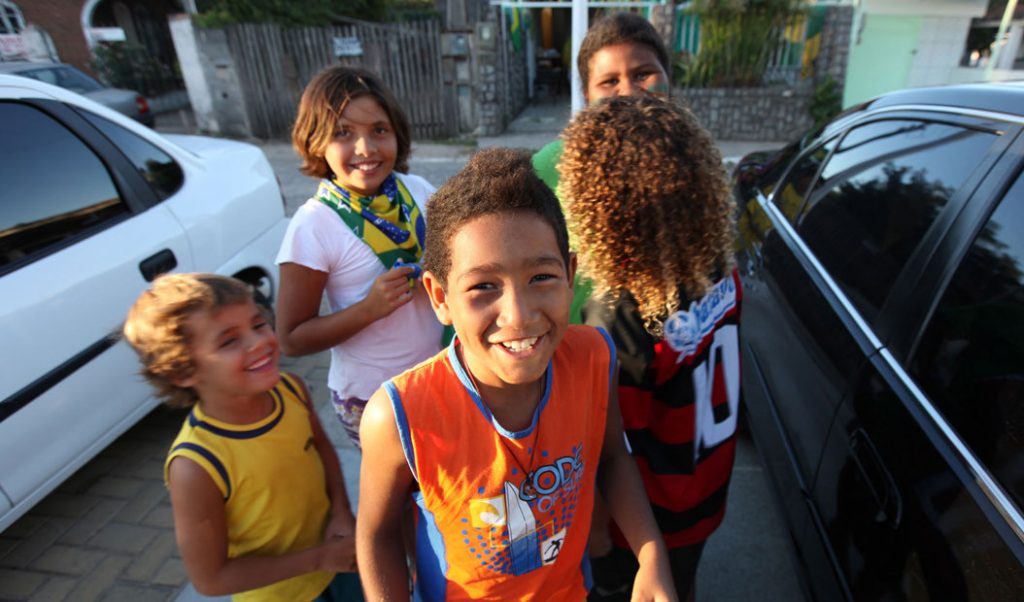 children smiling near cars